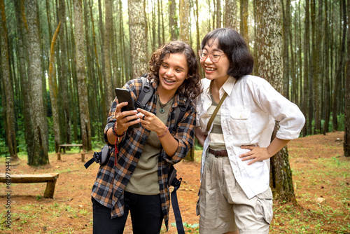 Two Asian women trekking together in the forest © Leo Lintang