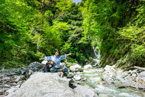 日本を旅している若いアジア人女性/渓谷で景色を眺めながら休憩をしている 