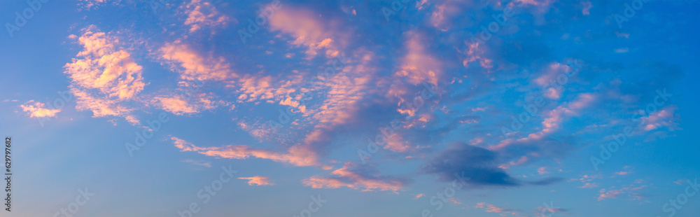 Panorama of the real sky at sunset time with pink light clouds. Gentle color of dawn, sunset.
