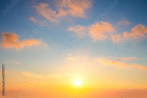 Pastel cloudscape. Sunrise sundown sky with gentle  colorful clouds without any birds. With sun. © Taiga