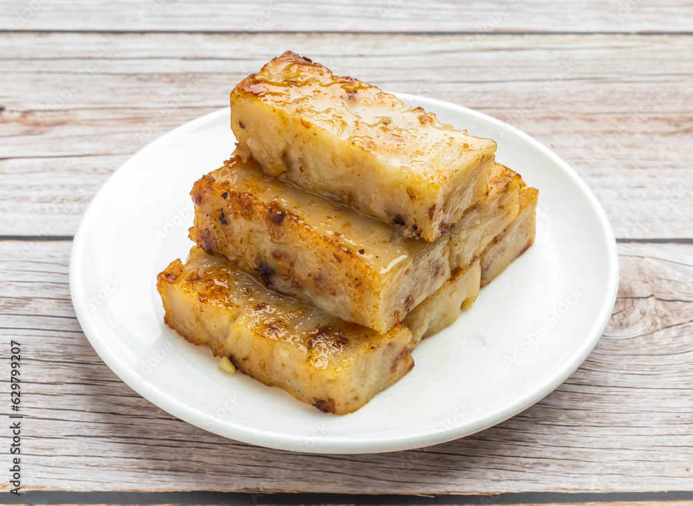fried white turnip cake served in dish isolated on wooden table top view hong kong food fried white turnip cake served in dish isolated on wooden table top view hong kong food