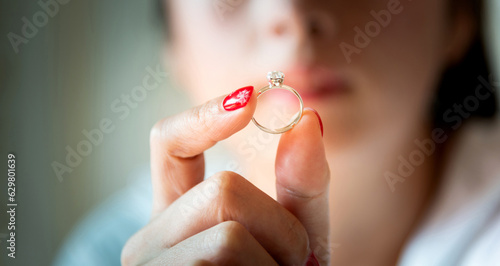 Young woman showing wedding ring in hand photo