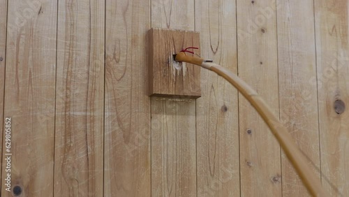 Stringing a Japanese yumi bow for kyudo japanese archery in wall stringing block. photo