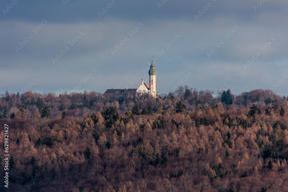 At the Ammersee the towers of Andechs monastery stand between wintry woods and the cloudy sky At the Ammersee the towers of Andechs monastery stand between wintry woods and the cloudy sky