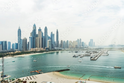 City of skyscrapers, Dubai marina in the sunny day with front line of beach hotels and blue water of Persian gulf. Dubai, UAE United Arabs Emirates.