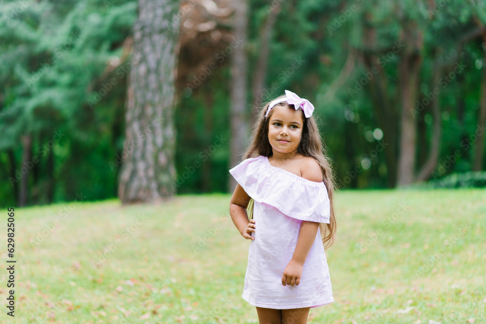 Naklejka premium A little child girl walks in the park in the summer. summer holidays in nature