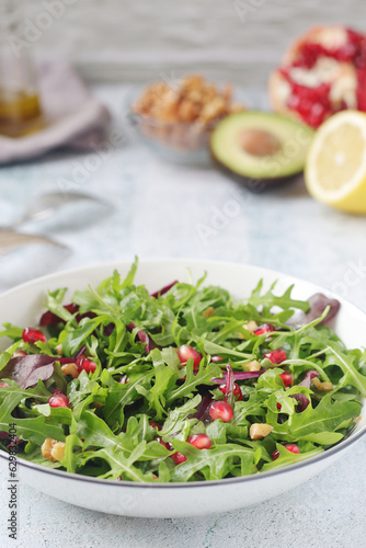 A plate with green rocket salad with pomegranate and avocado