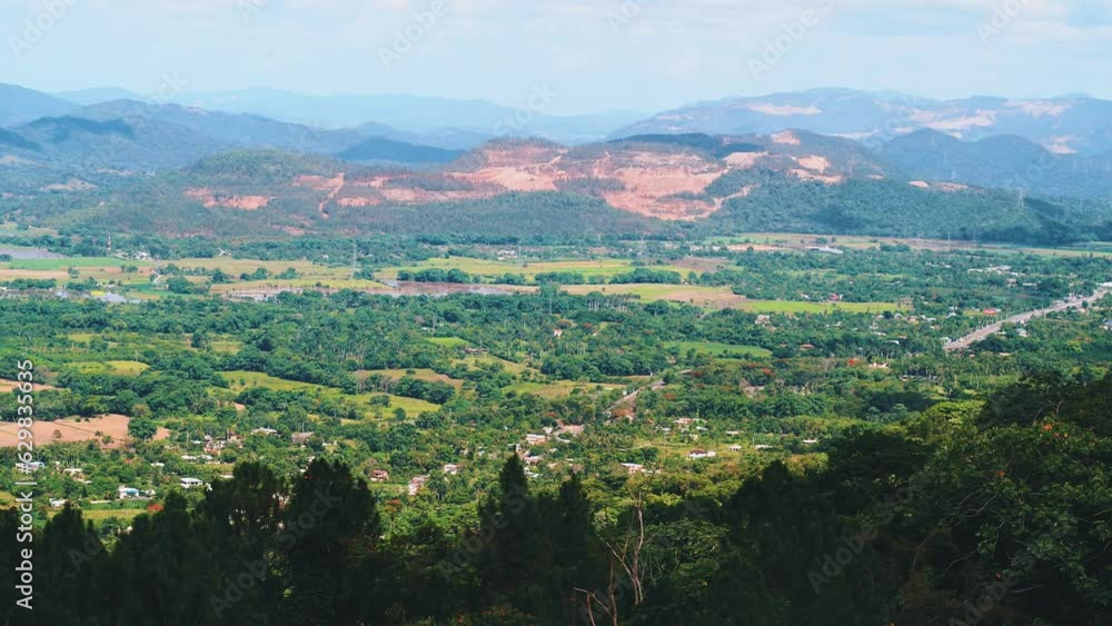 Scenic highlands of Dominican Republic in a sunny day. Colorful green meadows, fields, trees in summer in the valley. Panoramic landscape of a mountain valley. Journey to a tropical paradise. Scenic highlands of Dominican Republic in a sunny day. Colorful green meadows, fields, trees in summer in the valley. Panoramic landscape of a mountain valley. Journey to a tropical paradise.