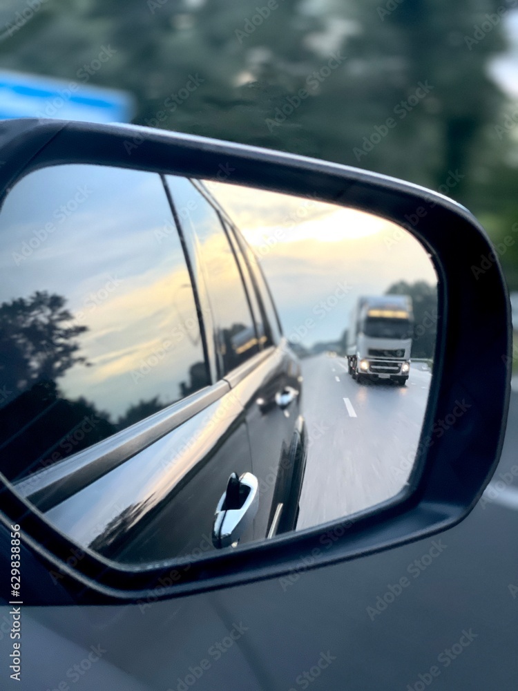 car on the road. Rearview mirror. The car is in motion. Car overtaking. Motorway. The car is in motion.