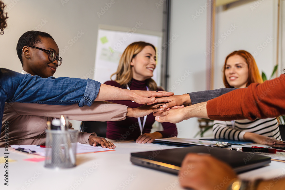 Group of businesspeople stacking their hands on top of each other Group of businesspeople stacking their hands on top of each other