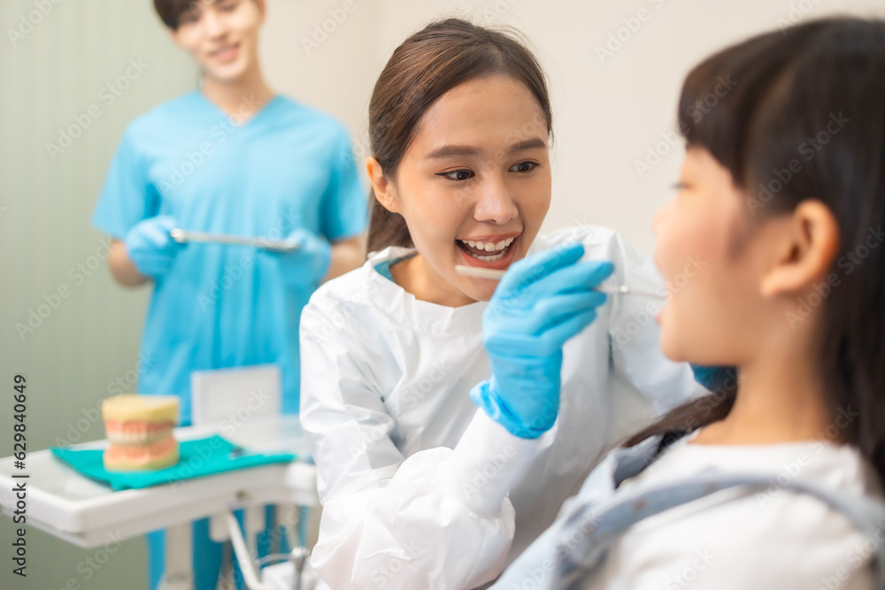 Happy female dentist with patient girl at clinic.Asian children's dentistry for healthy teeth and beautiful smile . Happy female dentist with patient girl at clinic.Asian children's dentistry for healthy teeth and beautiful smile .
