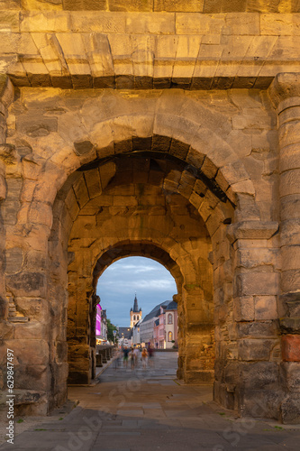 Fototapeta Naklejka Na Ścianę i Meble -  View through  the Porta Nigra,at sunset,  a Roman City Gate built after 170 AD and located in Trier, Germany