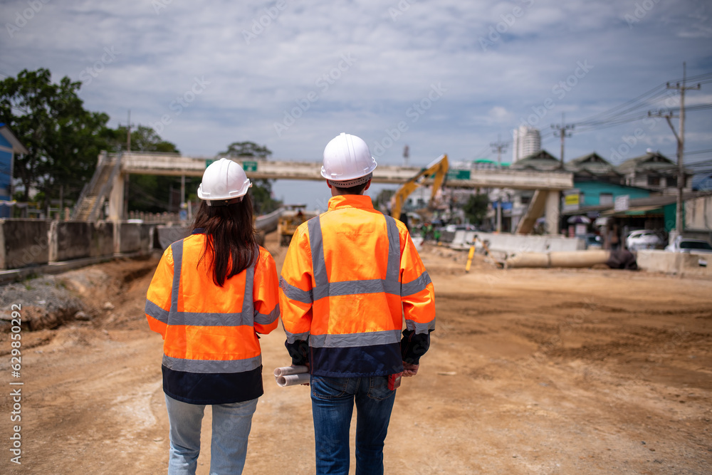 Portrait surveyors wearing uniform conversation and blueprint check inspection by theodolite camera to measurement level position road construction site is industry transportation concept