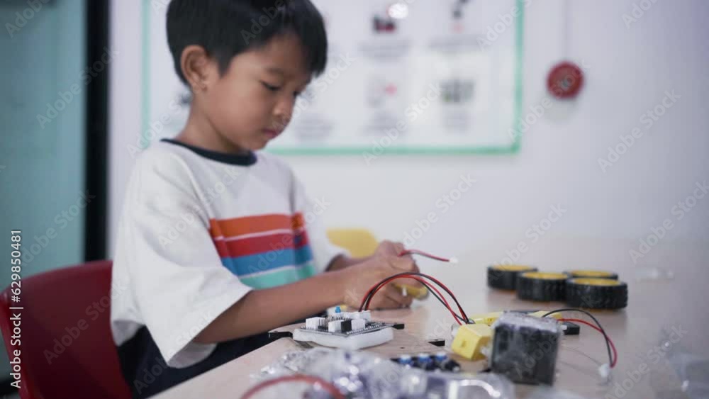 Kindergarten asian student learn in coding robot car and electronic board cable in STEM Arduino, Computer code in robotics for kids. Kindergarten asian student learn in coding robot car and electronic board cable in STEM Arduino, Computer code in robotics for kids.