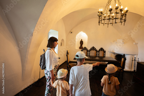 Mother and kids walking in the hall of the castle. photo