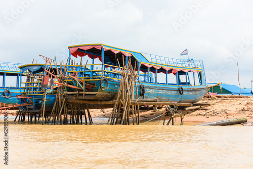 Wooden boats raised up on stilts on the Siem Reap river, Cambodia © Stephen