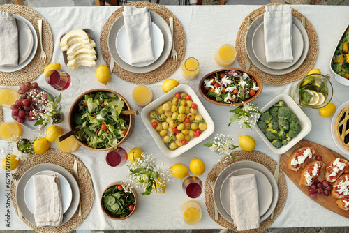 Top view of group of tasty and healthy homemade food and beverages standing on served table prepared for guests and family members