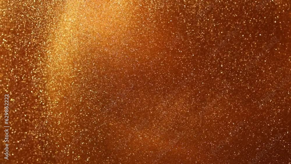 Slow Motion gold particles in liquid. A magical galaxy of countless golden dust particles in fluid motion. Abstract glistering background. Slow Motion gold particles in liquid. A magical galaxy of countless golden dust particles in fluid motion. Abstract glistering background.