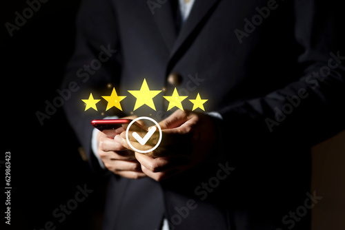 Fototapeta Naklejka Na Ścianę i Meble -  Businessman hand thumb rise up with 5 stars for customer satisfaction and product service evaluation concept, Good service experience. Best Rated 5 Stars for review.
