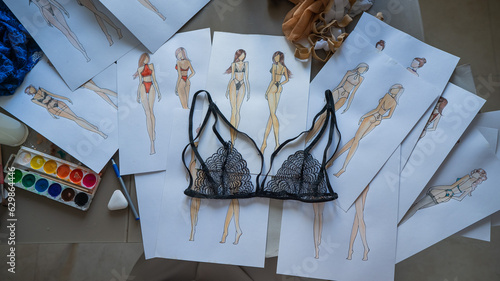 Faceless woman draws underwear sketches. Close-up of fashion designer's hands with lace bra.