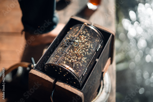 Hands roasting coffee with a home-made machine photo