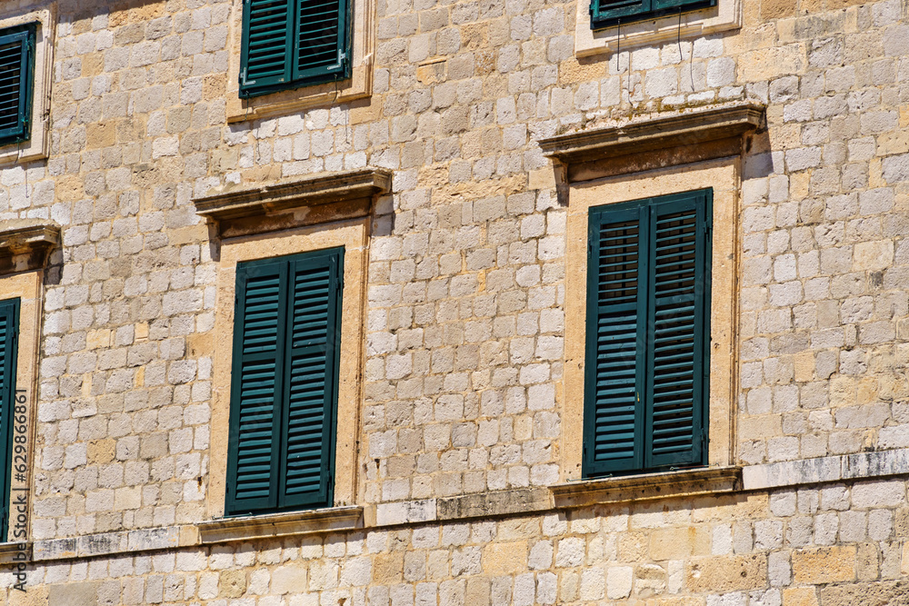 street view of the old town of Dubrovnik in Croatia, medieval European architecture, city streets, windows with wooden shutters, red tiled roofs, the concept of traveling in the Balkans