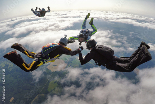 Skydivers make a 4-way formation over the cluds photo