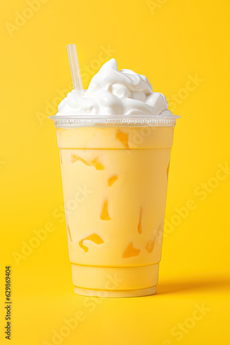 Mango smoothie milkshake in plastic takeaway cup isolated on yellow background