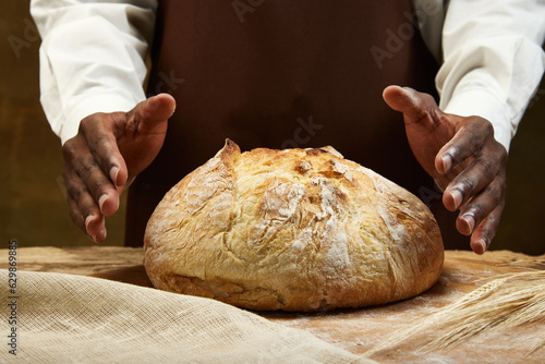 Traditional wedding round loaf of bread, and baker's hands.