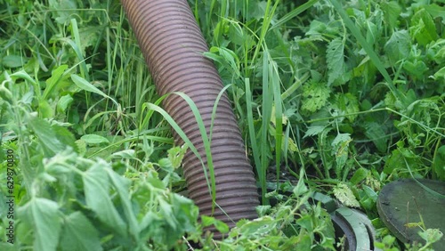 a pipe pumping out feces from a sewer in a rural area. sewerage repair, sewage, sewage pumping machine in the city photo