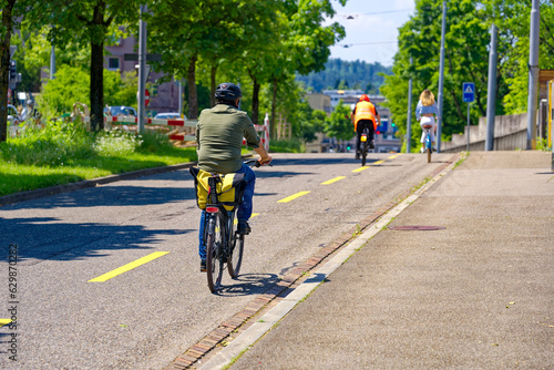 Urban road with bicycle lane and cyclists at City of Zürich on a sunny spring day. Photo taken May 26th, 2023, Zurich, Switzerland. © Michael Derrer Fuchs