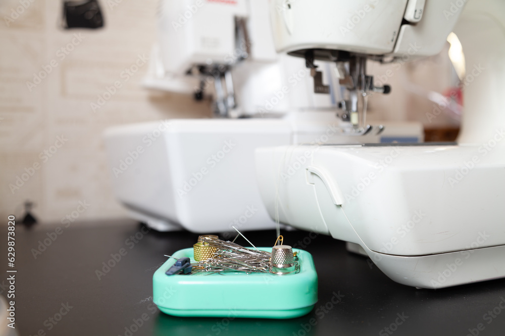 Small accessories for working  seamstress in front of sewing machine..