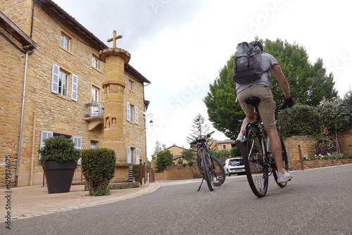 Cycliste en faisant du vélo dans le village de pierres dorées de Theizé, dans le Beaujolais, département du Rhône en région Auvergne-Rhône-Alpes, France