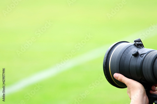 A professional photographer at a football field or sporting event