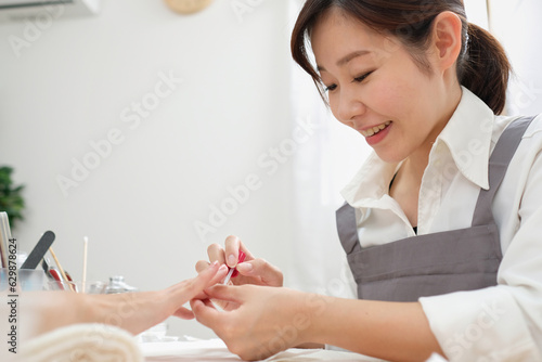顧客に施術をするネイリスト