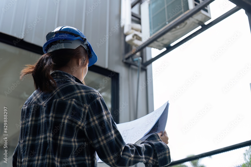 Civil Electrical engineers in safety helmet hard hat holding blueprint working while standing at factory. Civil Electrical engineers in safety helmet hard hat holding blueprint working while standing at factory.