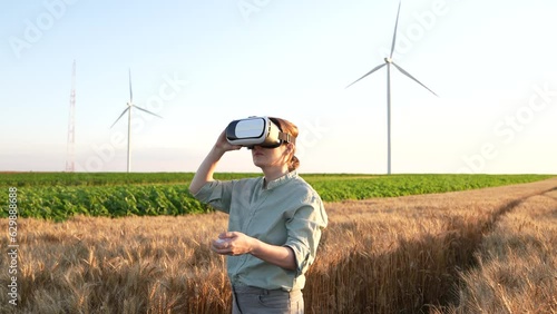 Farmer with VR glasses in corn field, wind turbines on the horizon