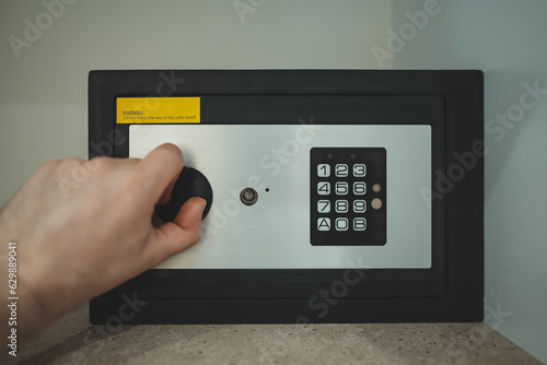 Man's hand opening small safe.