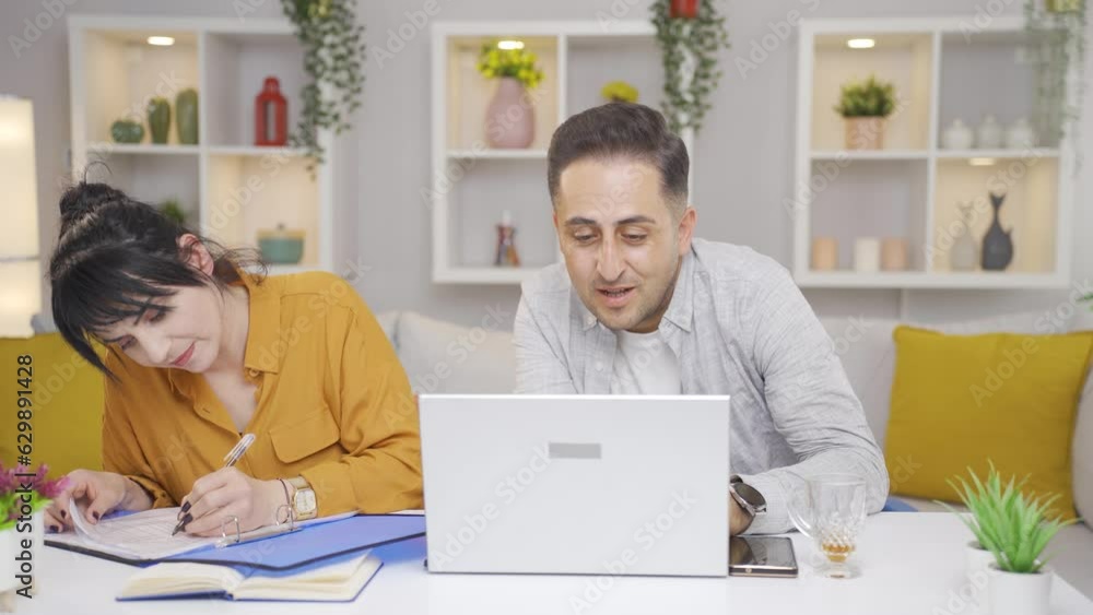 The married couple reviewing the file is thoughtful. The married couple reviewing the file is thoughtful.