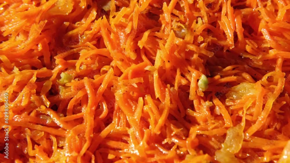 Grated carrots background. Spicy Carrot salad with dressing and spices, onion, garlic. Cooked chopped carrot. Asian dish with condiments, pepper. Food wallpaper spinning. Oriental cuisine. Full Frame Grated carrots background. Spicy Carrot salad with dressing and spices, onion, garlic. Cooked chopped carrot. Asian dish with condiments, pepper. Food wallpaper spinning. Oriental cuisine. Full Frame