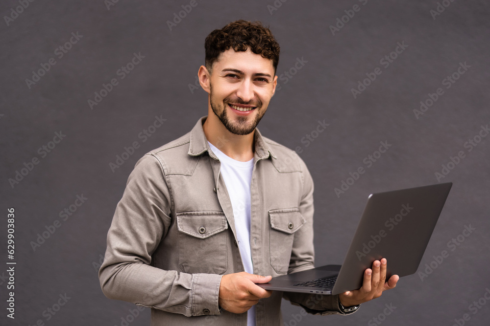 Smiling businessman in suit and glasses with laptop near office building Smiling businessman in suit and glasses with laptop near office building
