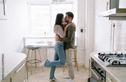 Happy couple kissing in kitchen. Enjoying Real Estate investments