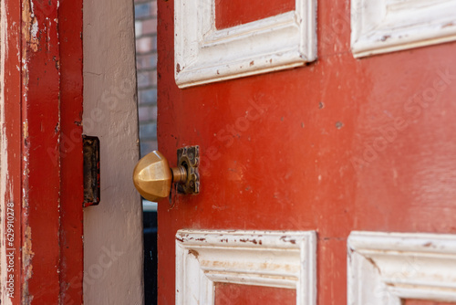 Photos Red and white door with a brass handle ajar