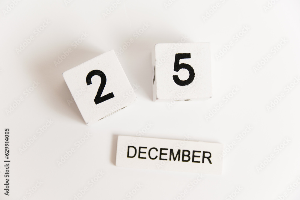 Wooden calendar with the date December 25 on a white background. The concept of preparing for the Christmas and New Year holidays.