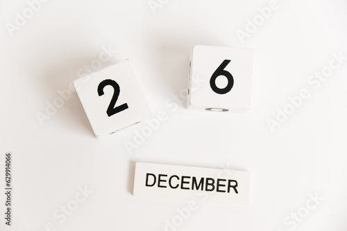 Wooden calendar with the date December 26 on a white background. The concept of preparing for the Christmas and New Year holidays.