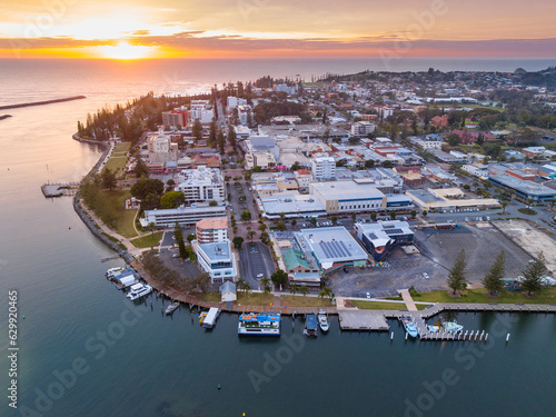 Aerial view of sunrise over a city waterfront on the the side of a river flowing out to the ocean photo