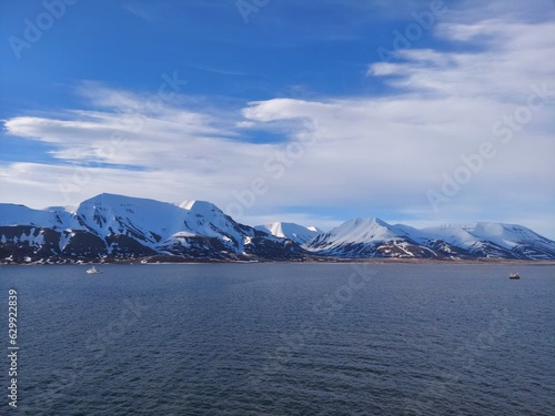 Architectural beauty against mountainous coastline with nautical vessel sailing on calm waters. a view from salbard longyearbyen norway