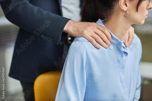 Obraz na plátne Closeup of inappropriate contact in office, male boss rubbing shoulders of young