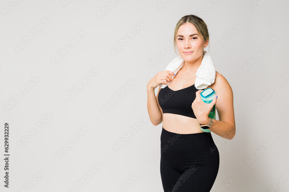 Caucasian active woman at the gym with water and a towel Caucasian active woman at the gym with water and a towel