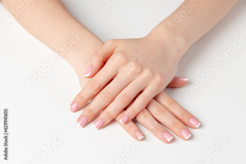 Well-groomed female hands with manicure on white background